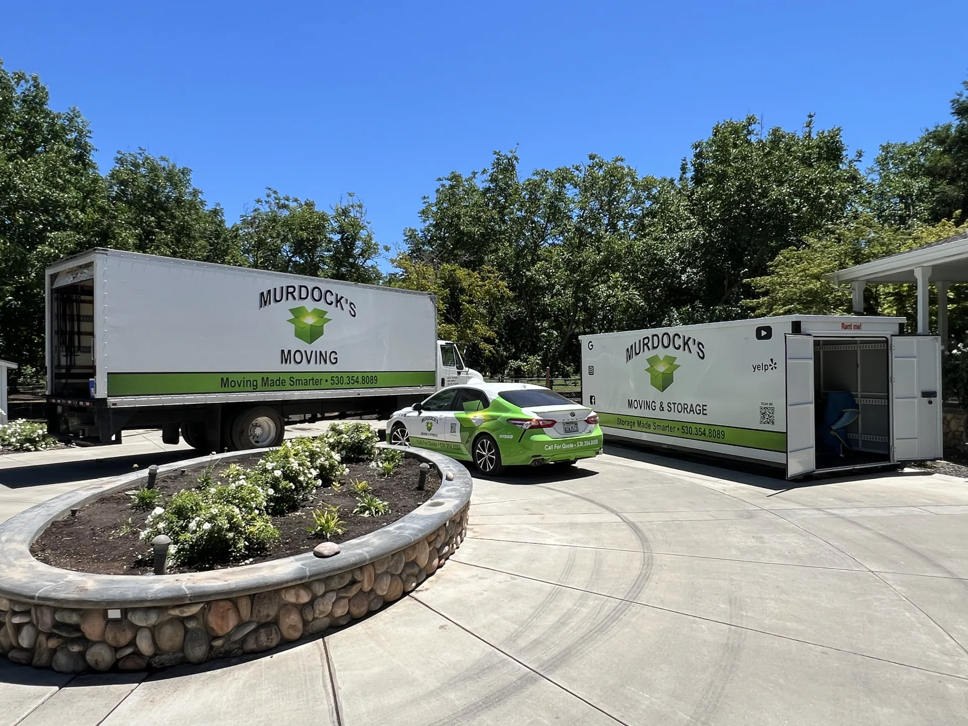 Murdock’s Moving box truck, branded company car, and MODS storage container at a Northern California home
